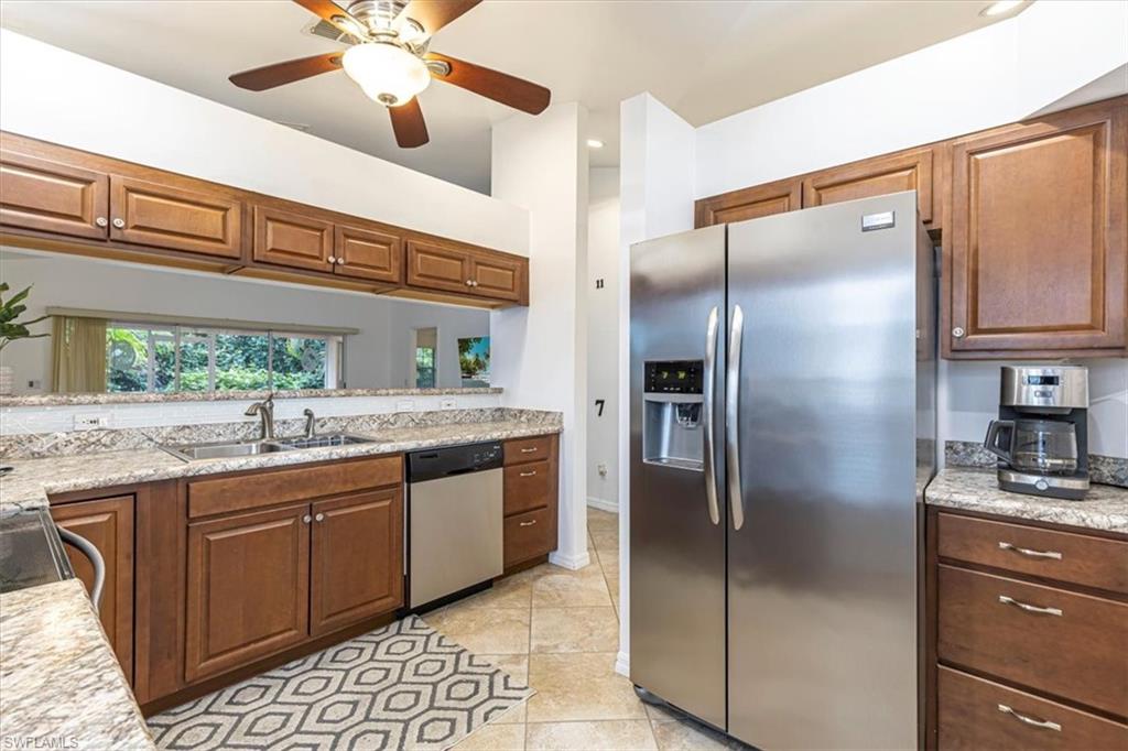 3609 Corinthian Way Naples, FL 34105 - Photo 7 of 23 Kitchen with stainless steel appliances, brown cabinetry, ceiling fan, light stone counters, and recessed lighting