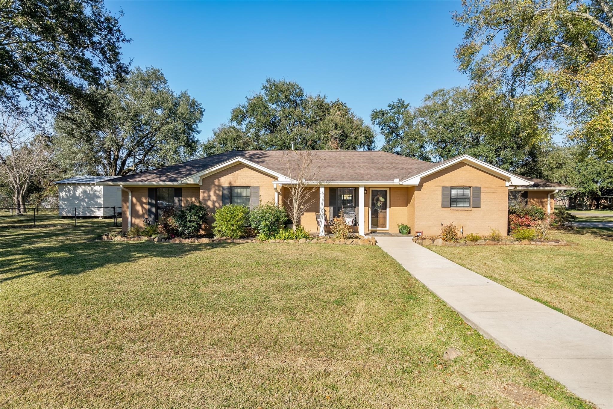 105 Alice Street Anahuac, TX 77514 - Photo 2 of 39 a front view of a house with yard and green space