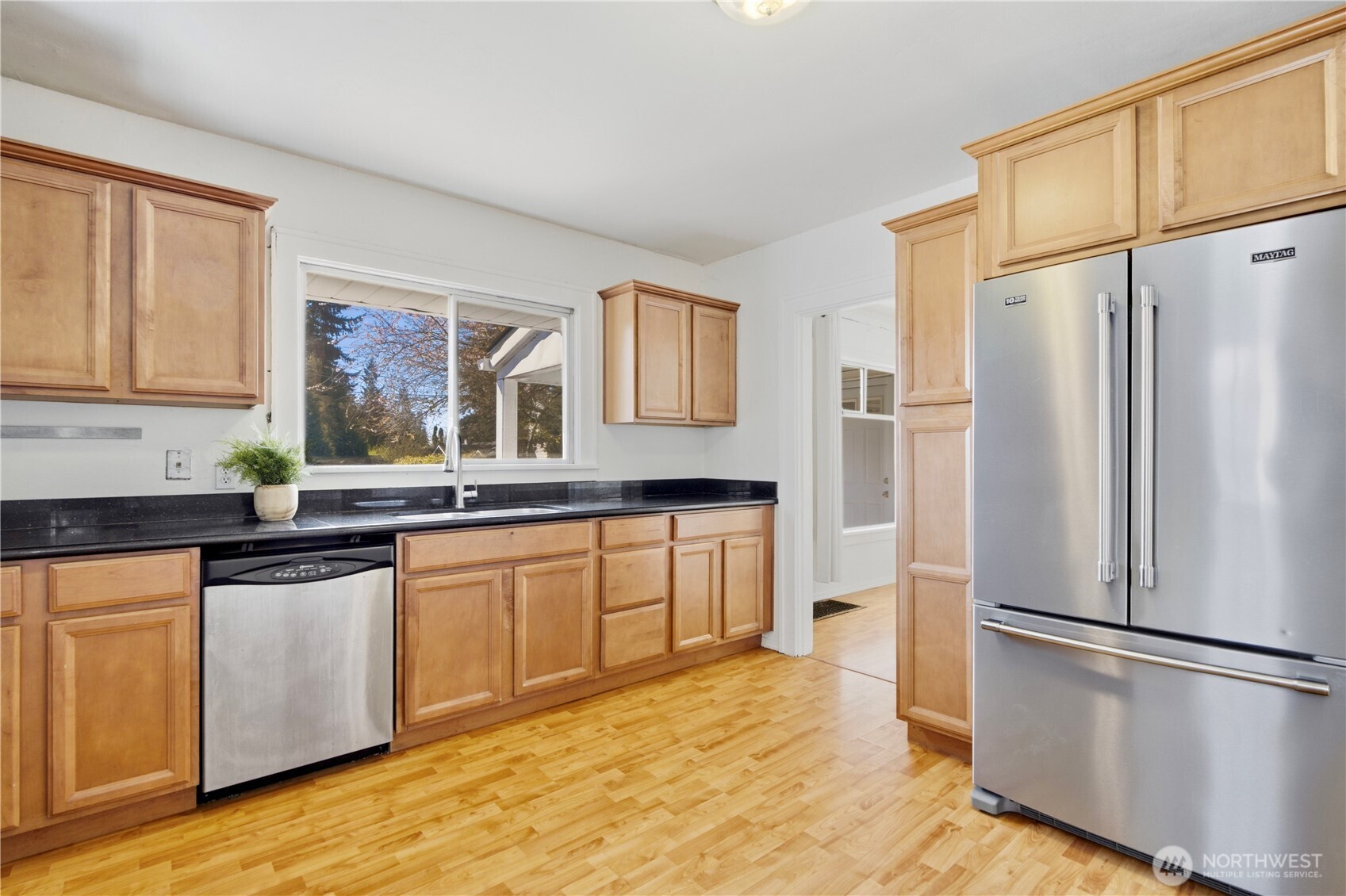 116 Northeast 133rd Street Seattle, WA 98125 - Photo 8 of 23 a kitchen with granite countertop stainless steel appliances a refrigerator a sink and cabinets