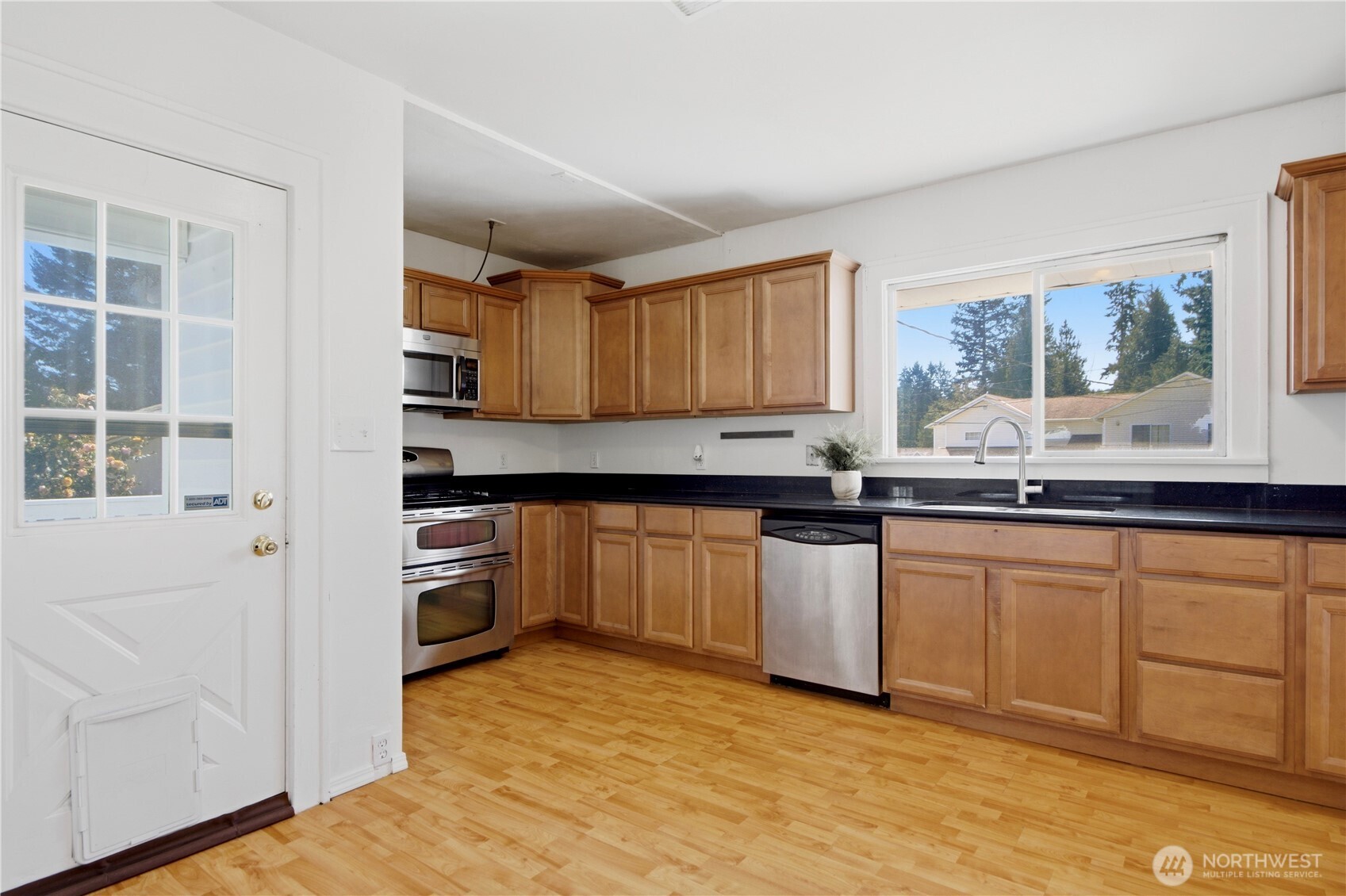 116 Northeast 133rd Street Seattle, WA 98125 - Photo 10 of 23 a kitchen with granite countertop a stove a sink and a refrigerator