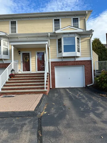 a view of a house with a garage and balcony