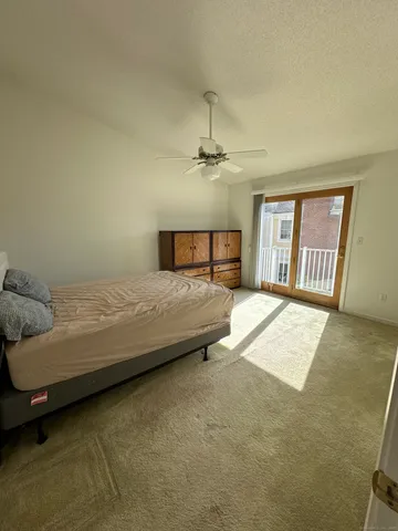 a spacious bedroom with a bed a couch and a large window