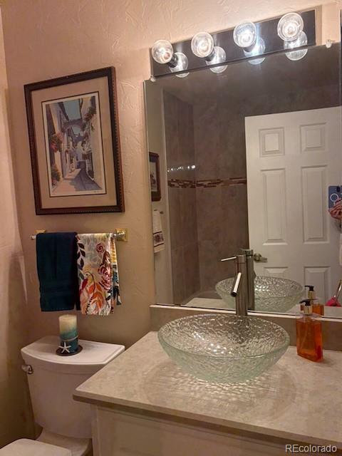 4 Shetland Court Highlands Ranch, CO 80130 - Photo 23 of 46 a bathroom with a granite countertop sink a mirror and vanity