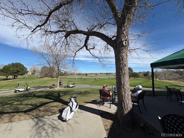 4 Shetland Court Highlands Ranch, CO 80130 - Photo 45 of 46 a view of a lake with couches and table and chairs under an umbrella