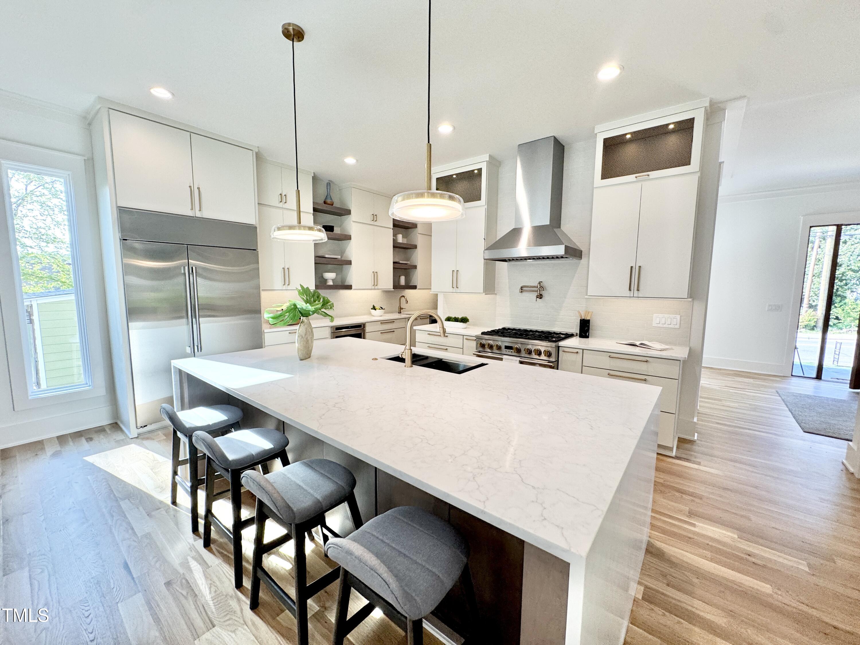 622 Glascock Street Raleigh, NC 27604 - Photo 20 of 81 a kitchen with stainless steel appliances a dining table chairs stove refrigerator and cabinets