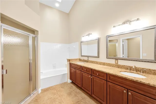 a bathroom with a granite countertop sink mirror and bathtub