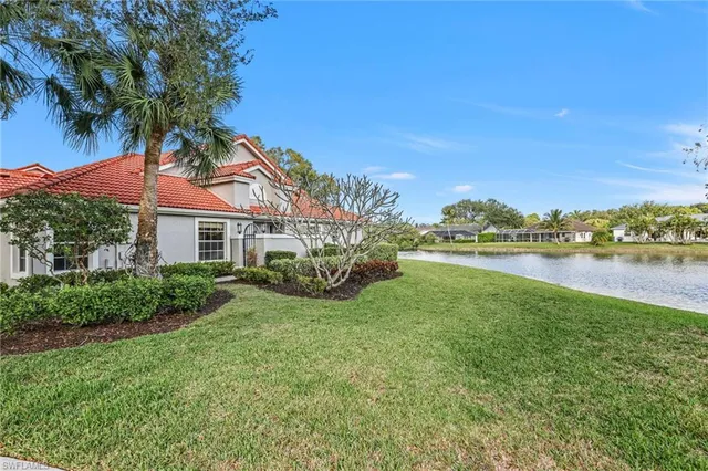 a front view of a house with garden and lake view