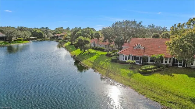an aerial view of a house with swimming pool and lake view