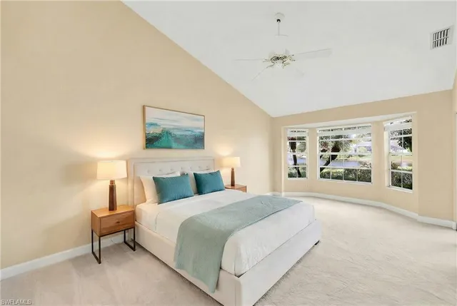 a spacious bedroom with a large bed and a chandelier