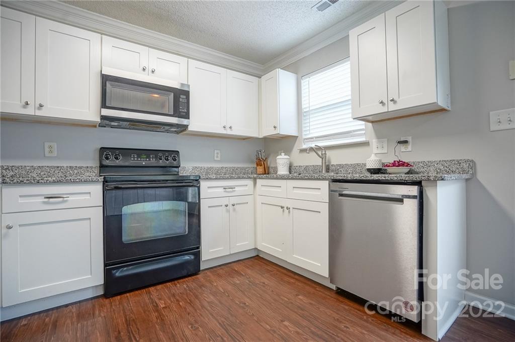 839 Matthews School Road Matthews, NC 28105 - Photo 12 of 37 a kitchen with granite countertop white cabinets and white appliances