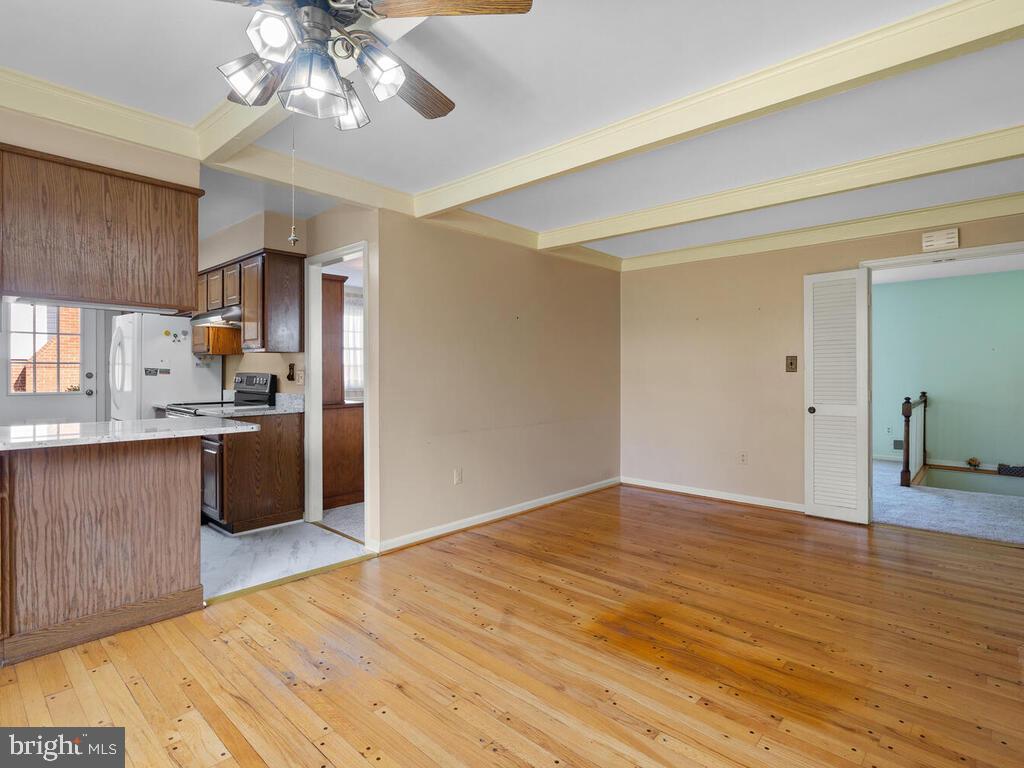 12714 Teaberry Road Silver Spring, MD 20906 - Photo 7 of 30 a view of an empty room and kitchen with wooden floor