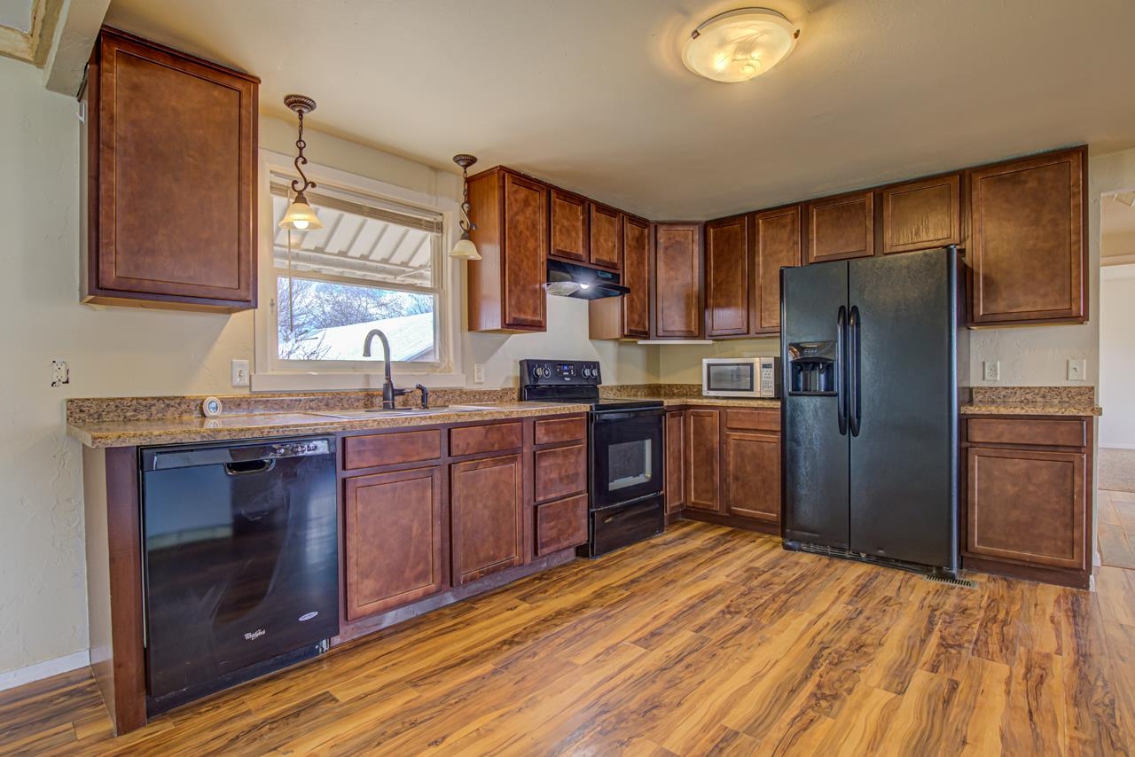 227 29 Road Grand Junction, CO 81503 - Photo 5 of 20 a kitchen with stainless steel appliances granite countertop a refrigerator a stove a sink and dishwasher with wooden floor
