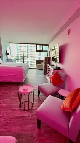 a view of a living room hardwood floor and a large window