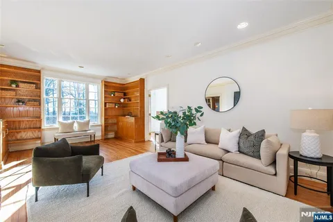 a living room with furniture potted plant and a large window