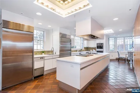 a kitchen with kitchen island stainless steel appliances a sink stove and refrigerator