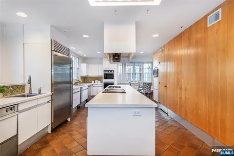 a kitchen with stainless steel appliances granite countertop a sink and a refrigerator