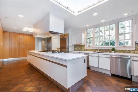 a large white kitchen with a large window