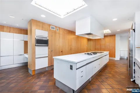 a large white kitchen with a stove a refrigerator and a sink