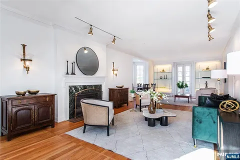 a living room with furniture a fireplace and a floor to ceiling window