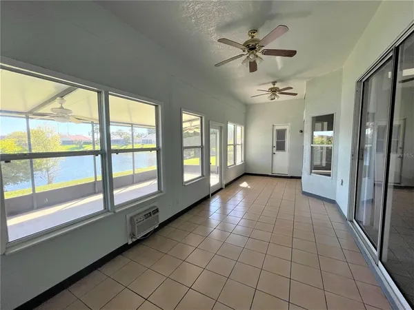 a view of an entryway with a chandelier fan and windows