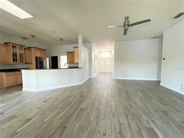 a view of a kitchen with wooden floor and electronic appliances
