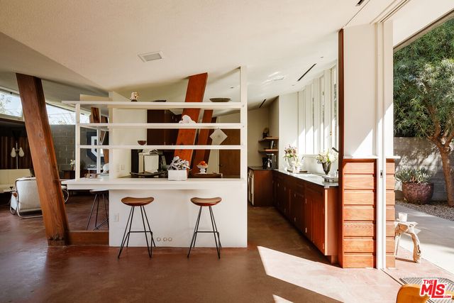 a view of a kitchen with kitchen island granite countertop a stove and a wooden floors