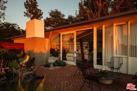 a backyard of a house with barbeque oven table and chairs