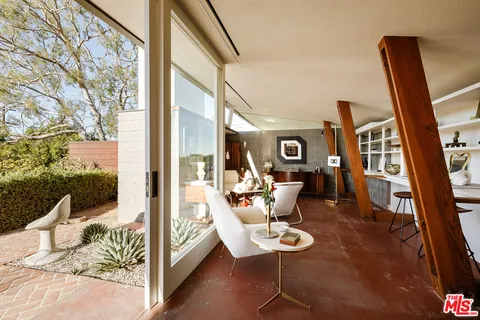 a living room with furniture and a floor to ceiling window