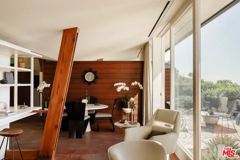 a living room with furniture and a floor to ceiling window