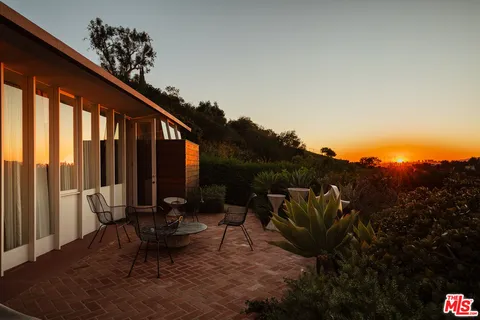 a view of balcony with chairs and a potted plant