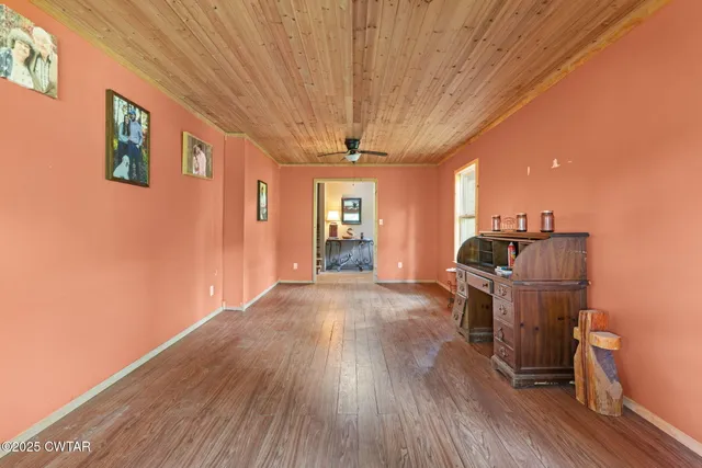 a kitchen with stainless steel appliances granite countertop a refrigerator a sink dishwasher a stove and a dining table with wooden floor