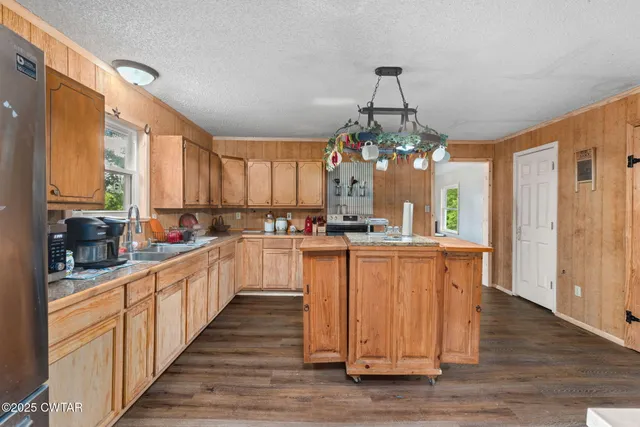 a kitchen with granite countertop a stove cabinets and wooden floor