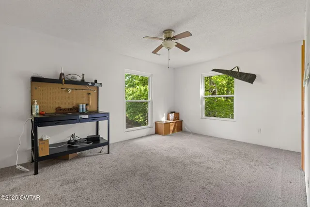 a view of a livingroom with a ceiling fan and window