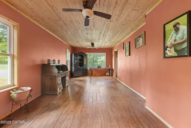 a view of a livingroom with furniture a ceiling fan and window