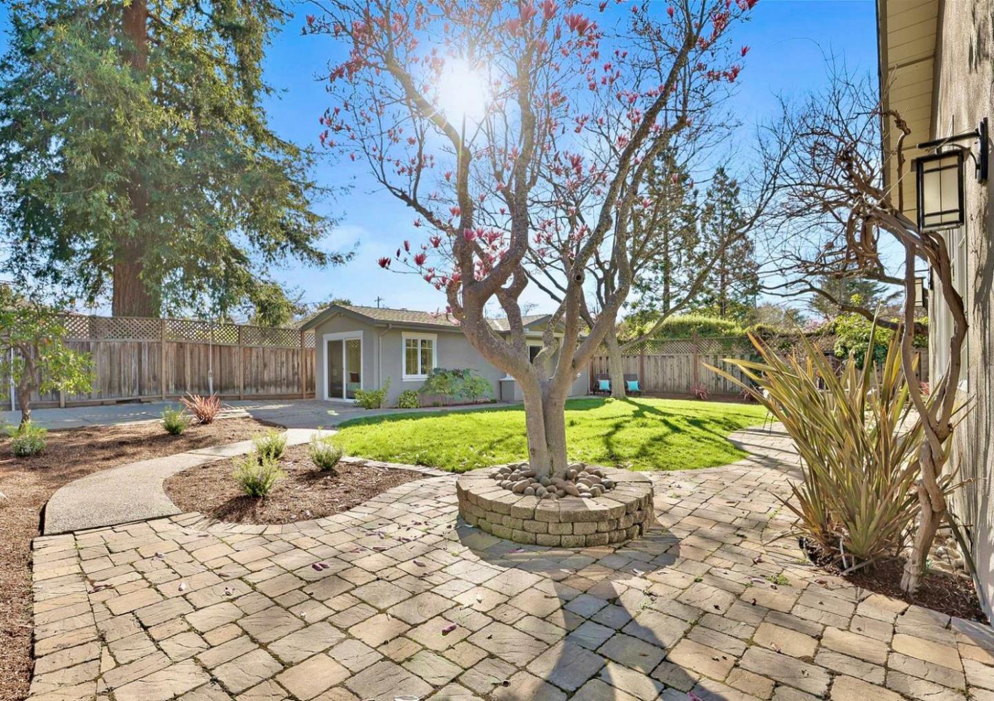 718 Covington Road Los Altos, CA 94024 - Photo 47 of 49 a view of a backyard with table and chairs plants and wooden fence