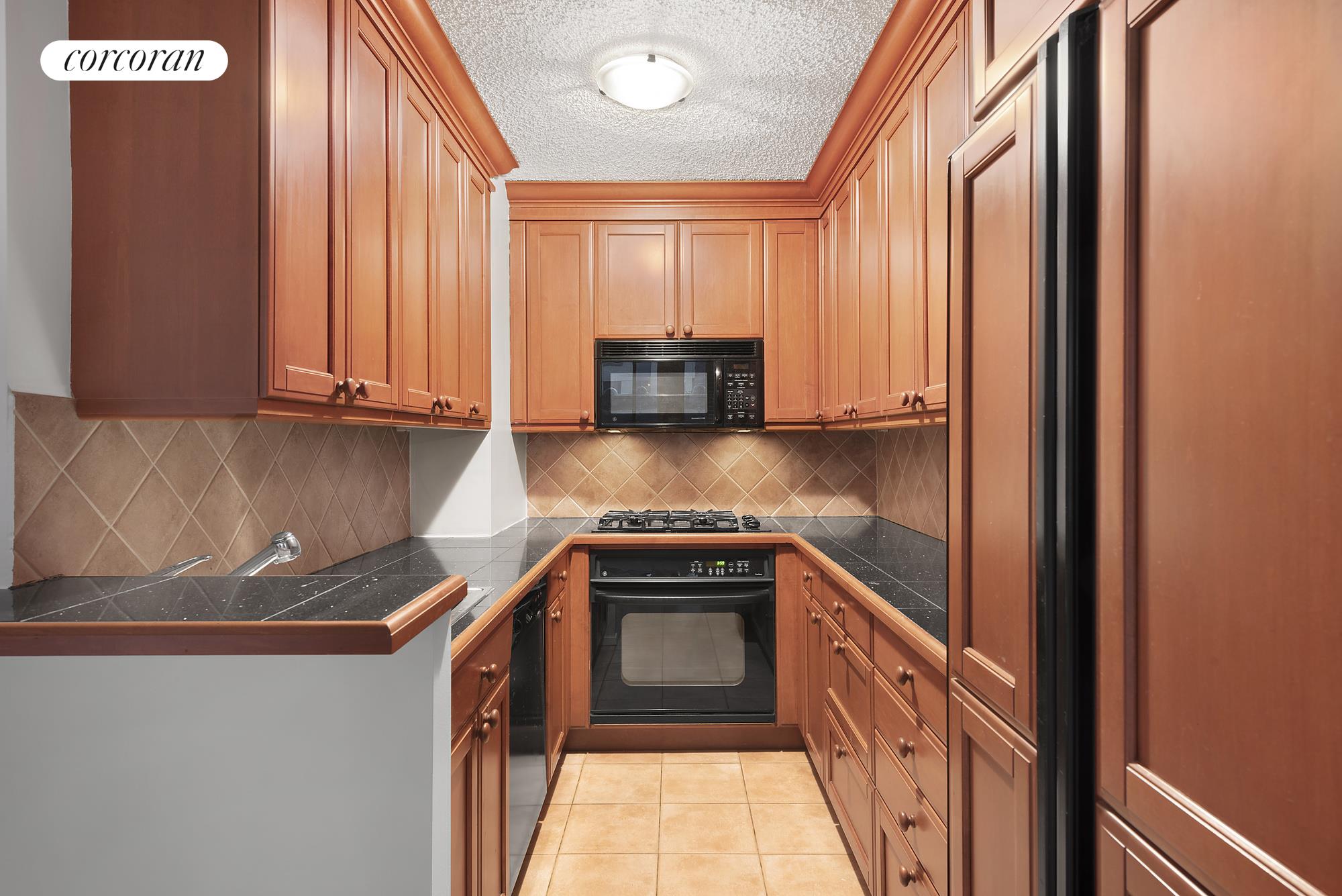 445 5th Avenue, Unit 16F Manhattan, NY 10016 - Photo 3 of 8 a kitchen with stainless steel appliances granite countertop a stove a sink and a microwave