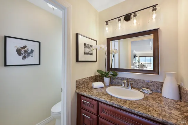 a bathroom with a granite countertop sink and a mirror