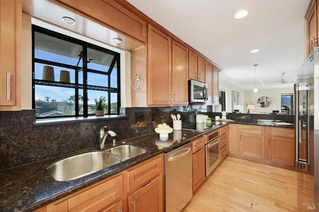 a large kitchen with granite countertop a sink and cabinets