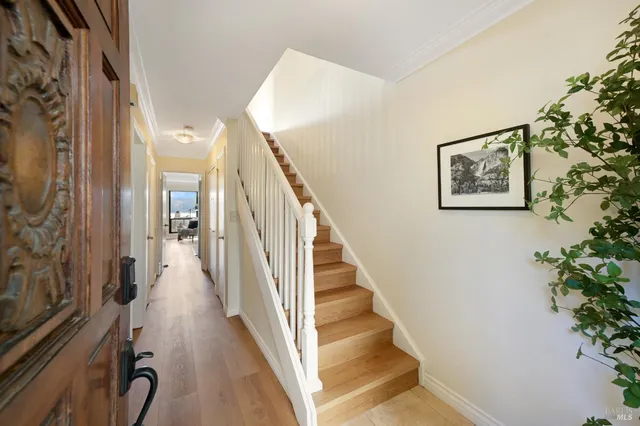 a view of a hallway with wooden floor and stairs