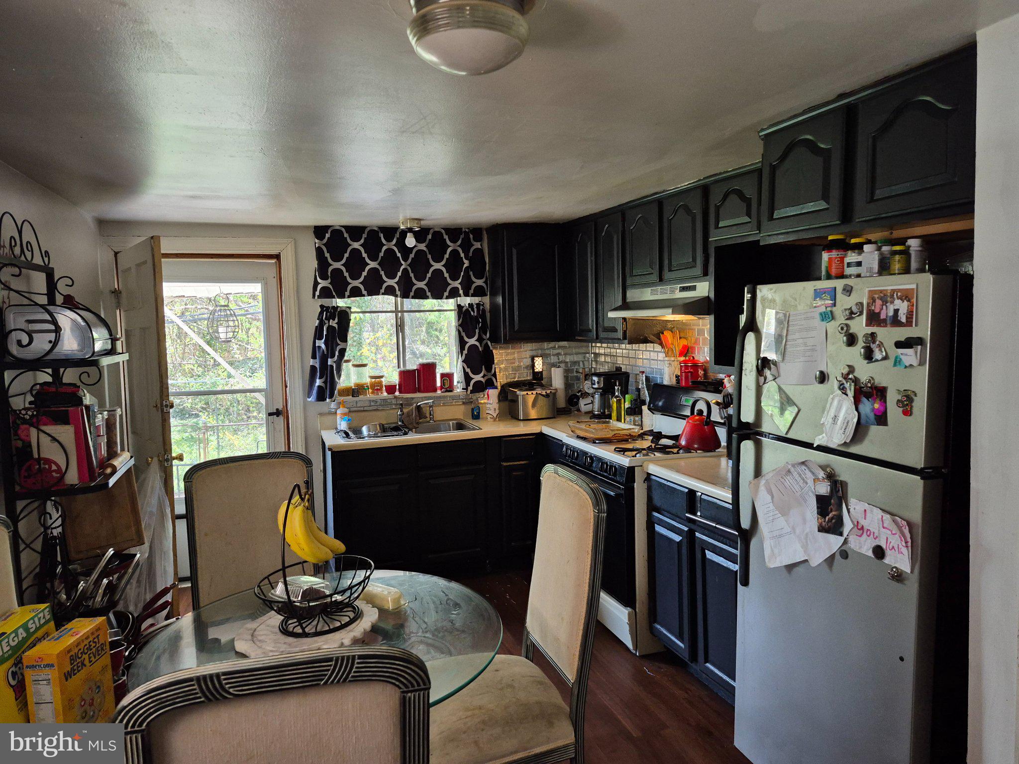 6016 West Thompson Street Philadelphia, PA 19151 - Photo 4 of 9 a kitchen with stainless steel appliances granite countertop a refrigerator a sink dishwasher a dining table and chairs with wooden floor