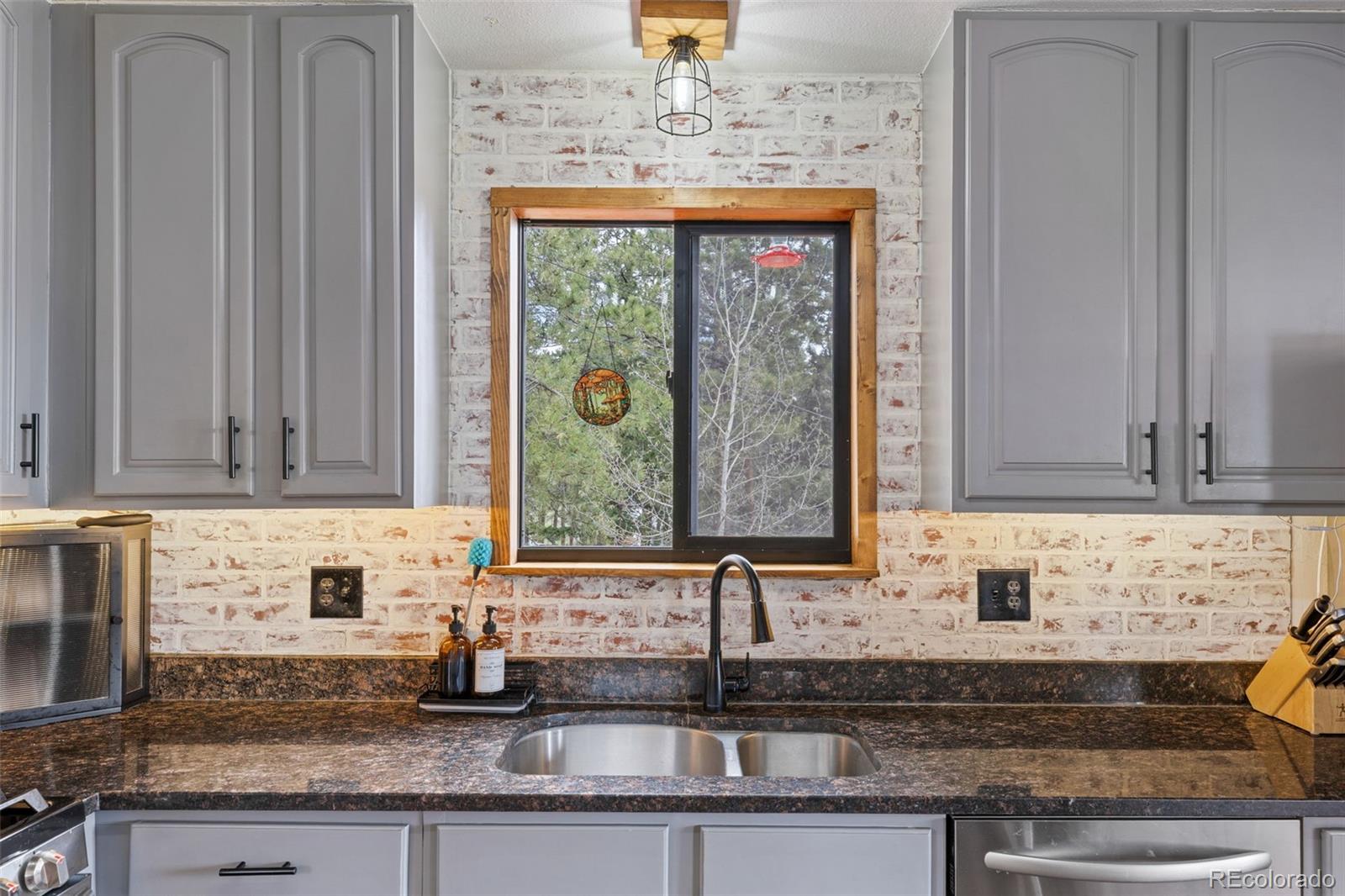 518 Pine Drive Bailey, CO 80421 - Photo 14 of 43 a kitchen with stainless steel appliances granite countertop a sink a stove and a granite counter tops