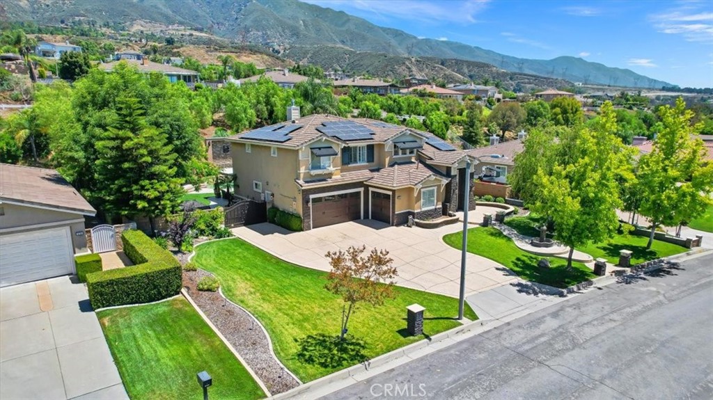 a view of a house with a big yard plants and large trees