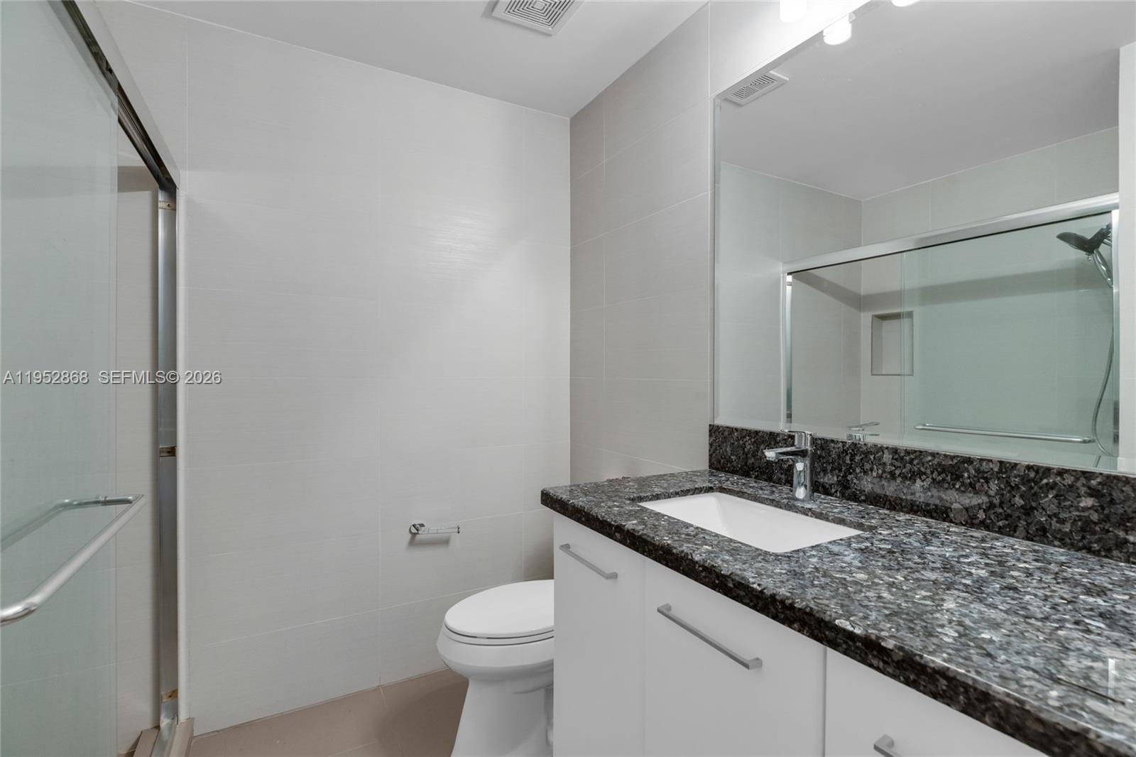 4441 Stone Ridge Way Weston, FL 33331 - Photo 48 of 87 a bathroom with a granite countertop sink a toilet and a mirror