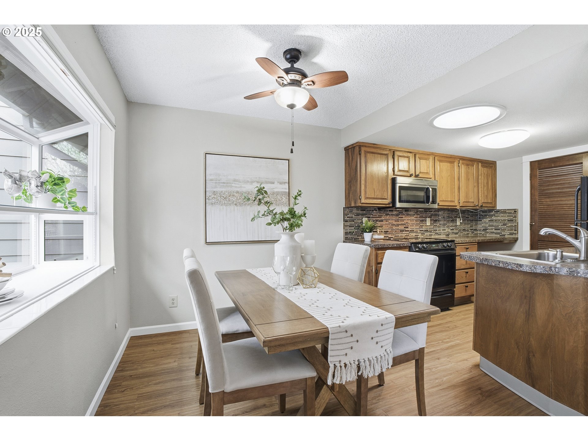 10955 Southwest Meadowbrook Drive, Unit 16 Portland, OR 97224 - Photo 11 of 26 a view of a dining room with furniture a chandelier and a window