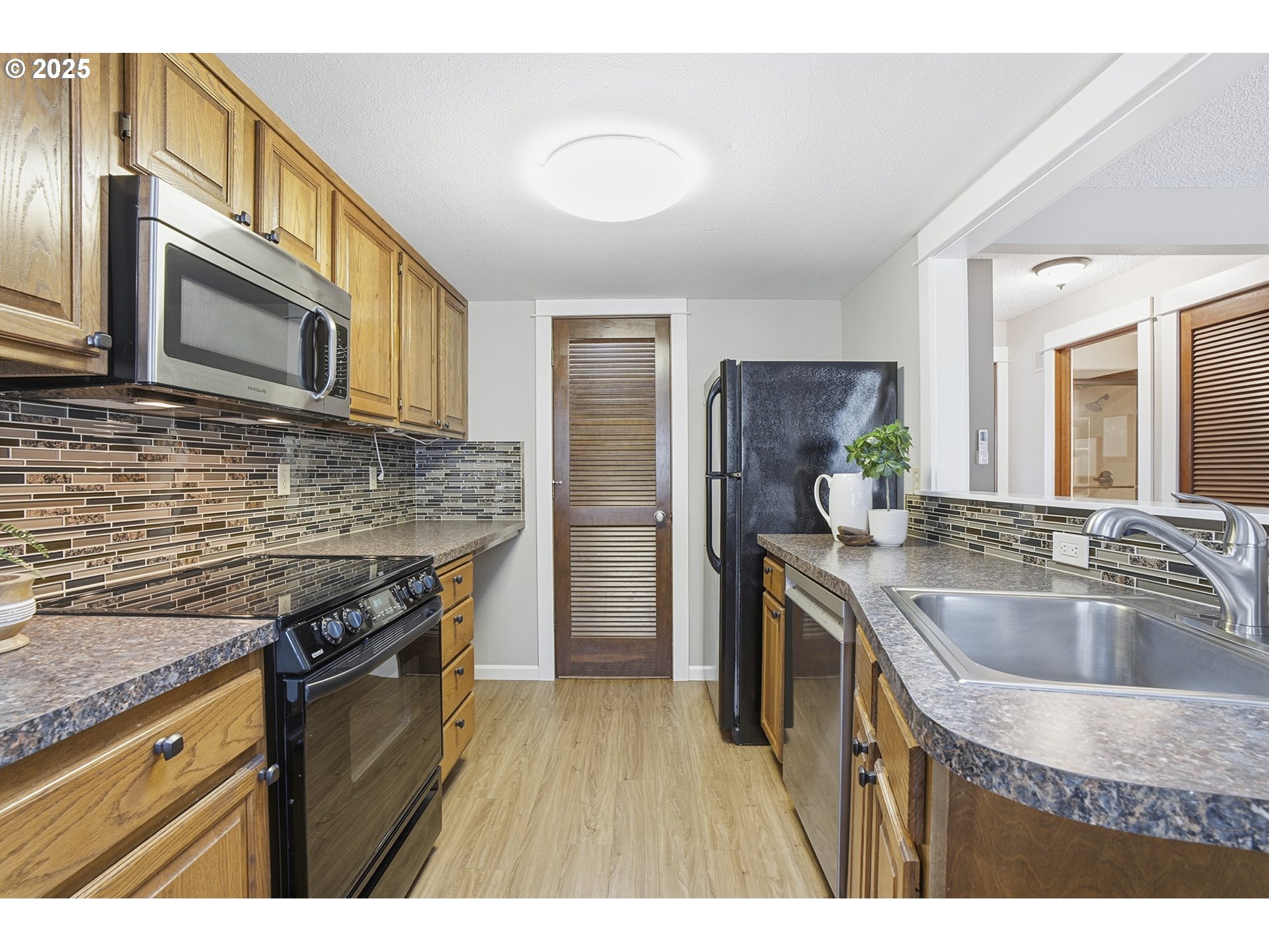 10955 Southwest Meadowbrook Drive, Unit 16 Portland, OR 97224 - Photo 13 of 26 a kitchen with stainless steel appliances granite countertop a sink stove and refrigerator