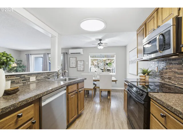 a kitchen with stainless steel appliances granite countertop a sink stove and cabinets
