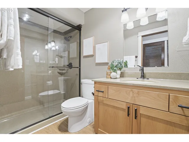 a bathroom with a sink a toilet and shower