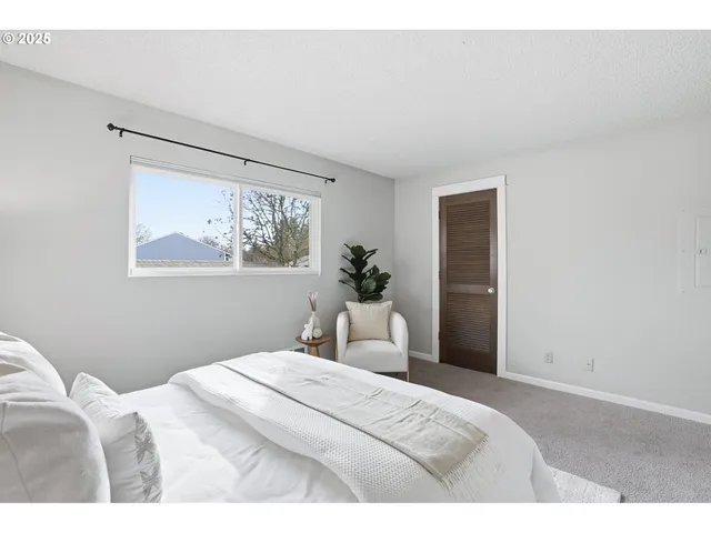 a bedroom with a bed and a painting on the wall