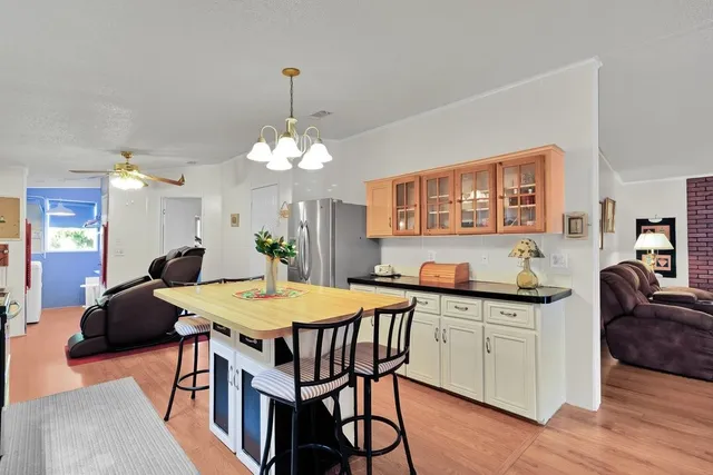 a kitchen with stainless steel appliances granite countertop a sink a stove a dining table and chairs