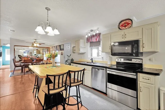 a kitchen with stainless steel appliances refrigerator dining table and chairs